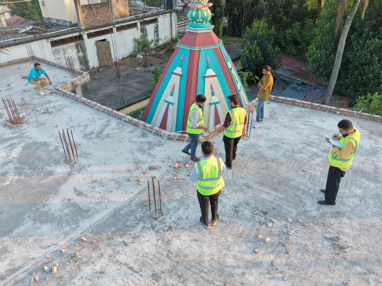 Team members in vests measuring a rooftop while a colleague takes notes
